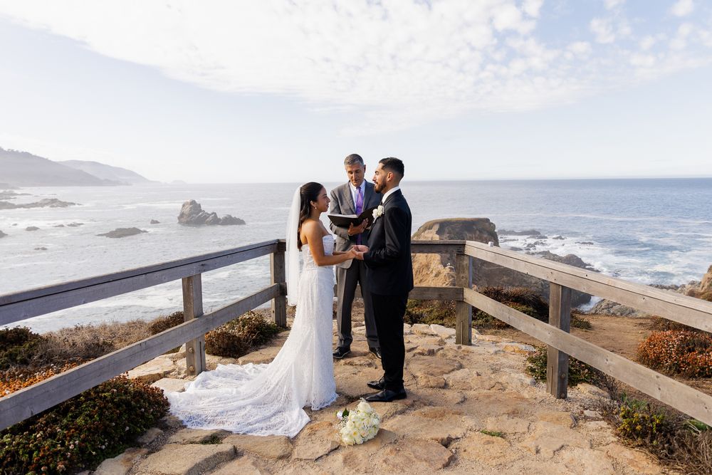 Couple exchanges vows at a scenic coastal wedding ceremony with ocean views at Big Sur, California.