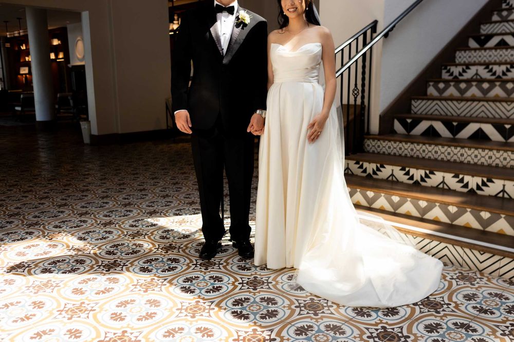 Wedding couple walks on ornate patterned tile floor in elegant venue during their special day celebration.