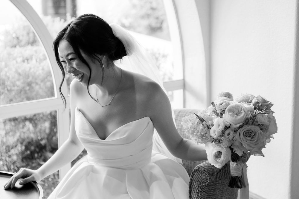 Black and white candid moments of wedding day preparations with white floral bouquets and elegant bridal attire.