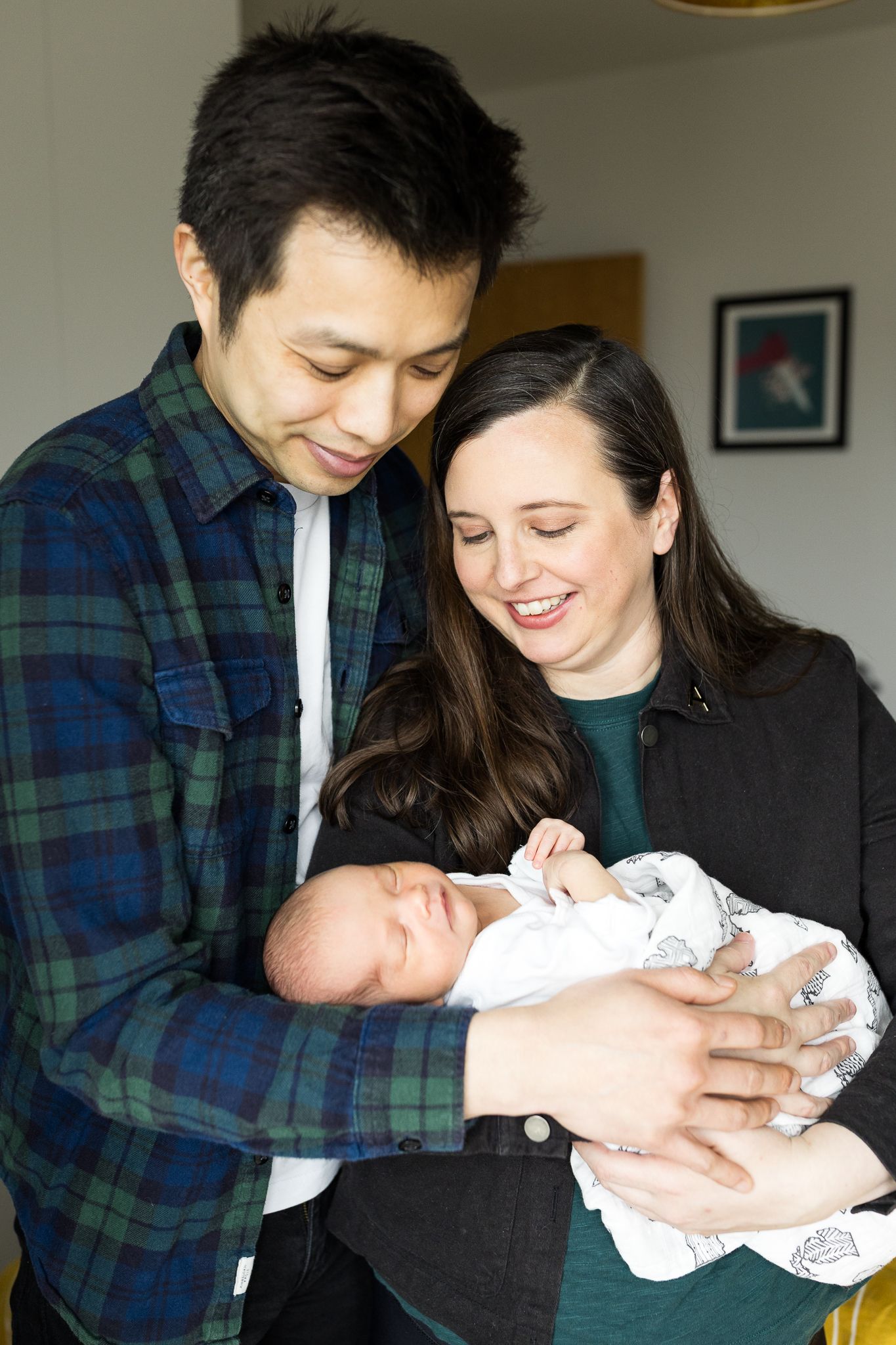 happy mum and dad holding baby girl in their arms