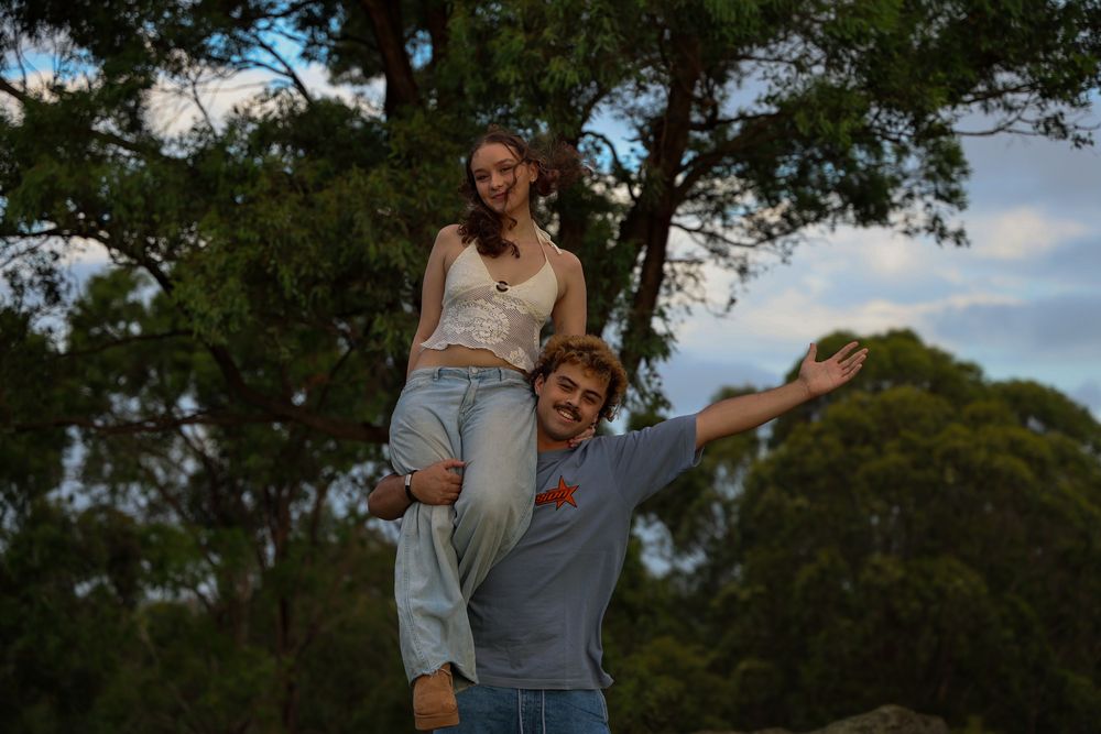 A young woman being lifted up by her boyfriend while both smiling