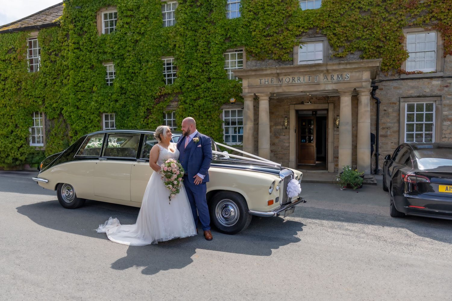 A classic vintage Rolls Royce wedding car parked outside an ivy-covered stone mansion. Wedding Morritt Arms County Durham