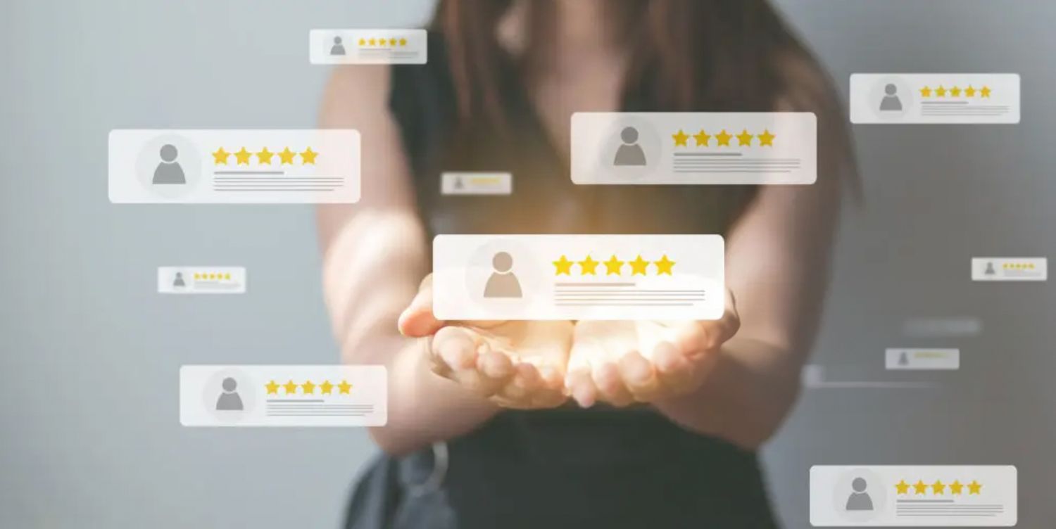 Cupped hands glow while holding a five star customer rating review floating among other profile ratings in dark space.