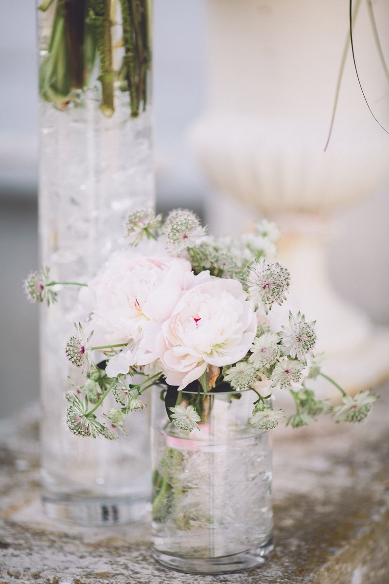 Delicate wedding flowers arranged in small glass vases at Château Barthélemy