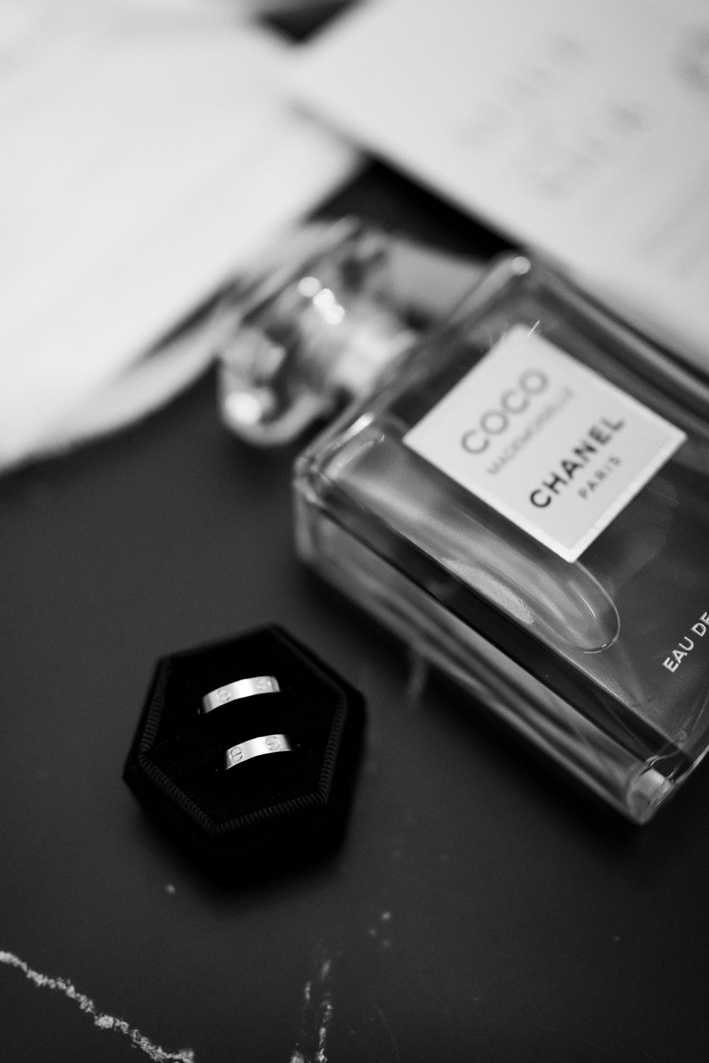 Brides details, perfume and rings in black and white.