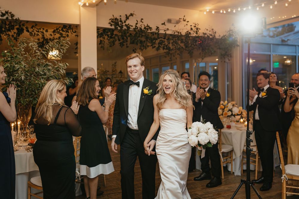 Elegant wedding reception at an indoor venue with floral decor and string lights creating a romantic atmosphere.