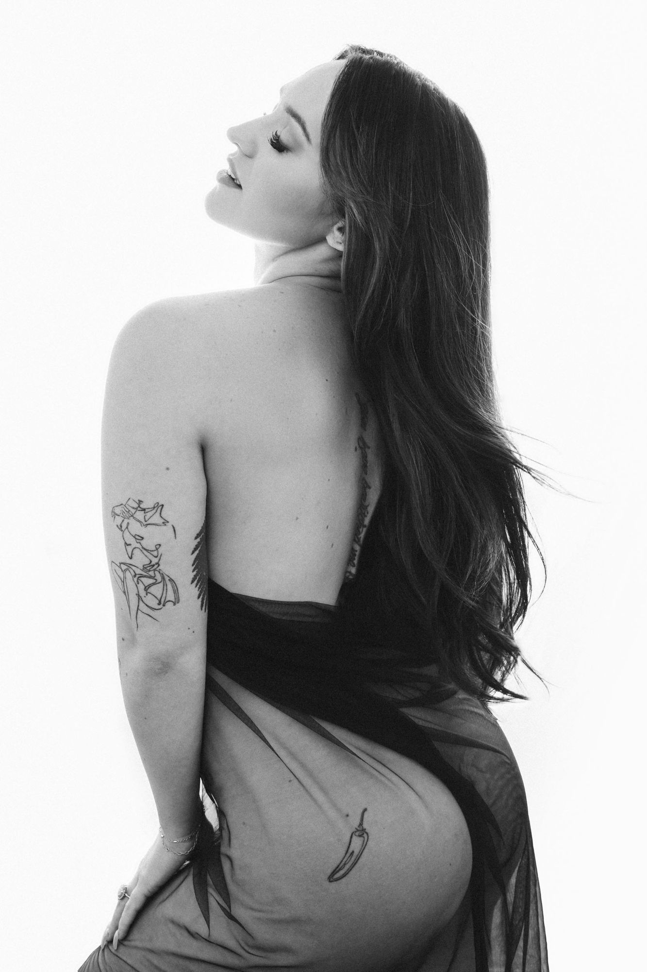 Black and white artistic portrait series showing a woman with long dark hair in dramatic poses against white background.