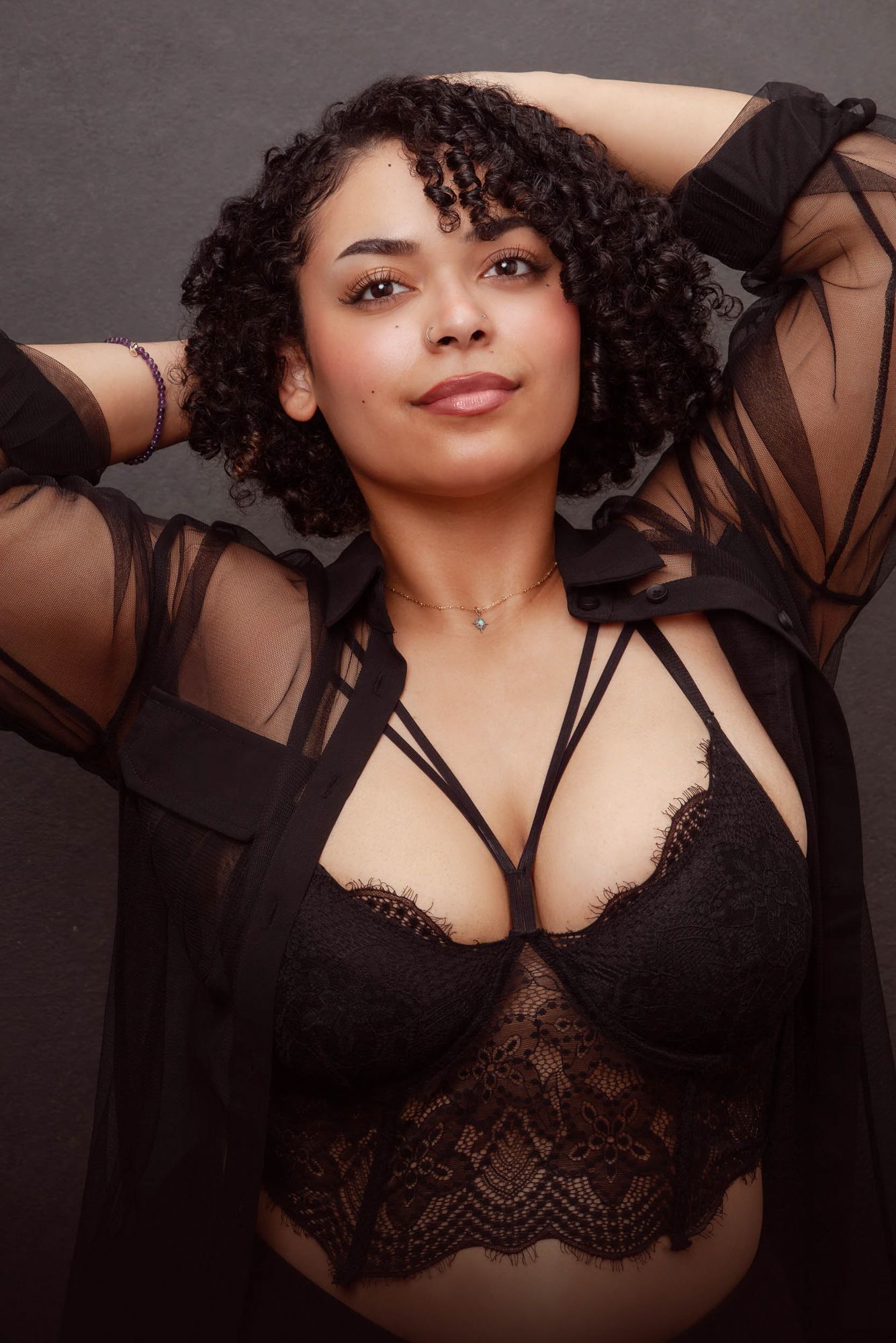 Boudoir photography series featuring a woman in black lace lingerie posing against dark background.