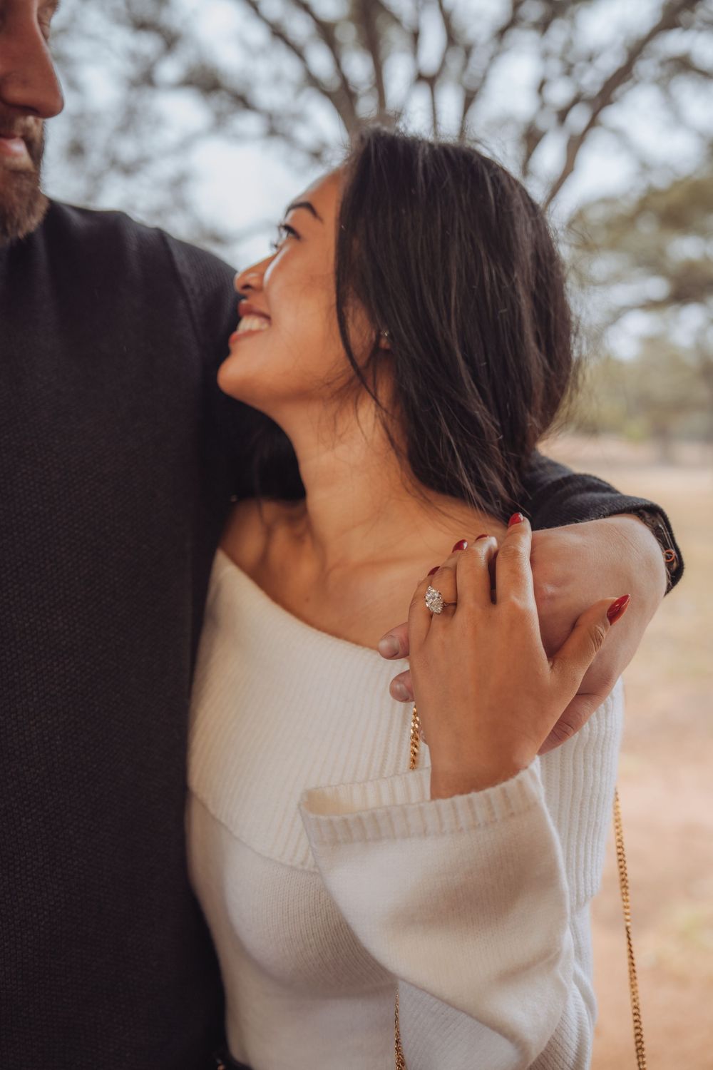 A romantic moment captured in soft lighting showing a couple embracing in white and dark clothing.