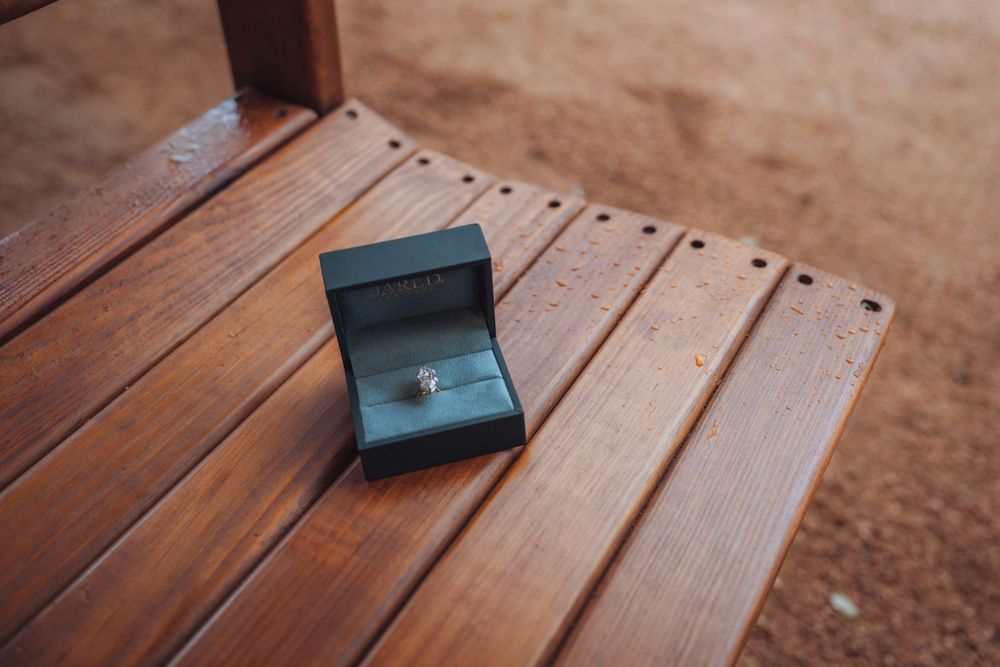 Small jewelry boxes arranged on rustic wooden planks in warm lighting.