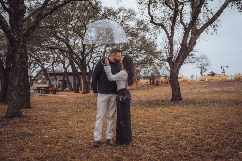 A romantic outdoor photoshoot on a golden hillside with autumn trees in the background.