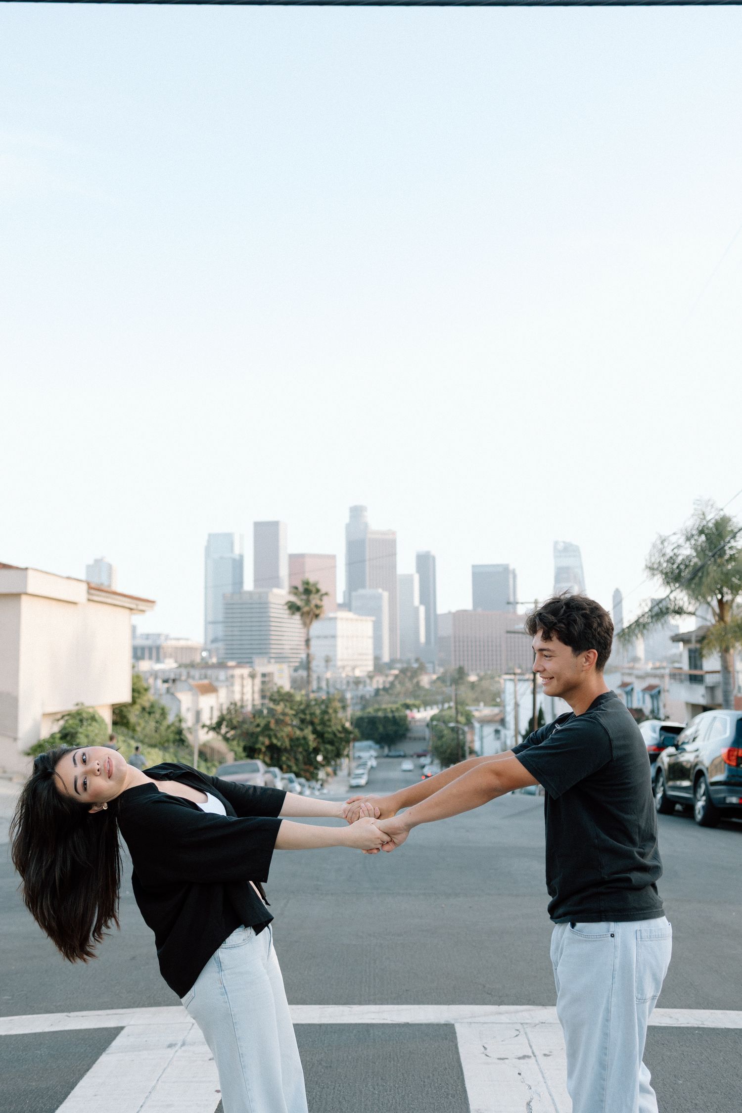 A series of dance poses shows two people performing a dramatic dip move against an urban cityscape backdrop.