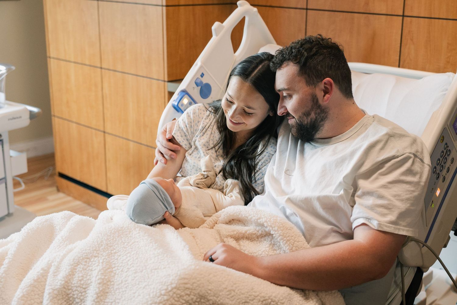 New mom and dad being photographed with their newborn baby in a Fort Worth hospital by a Fort Worth TX family photographer.