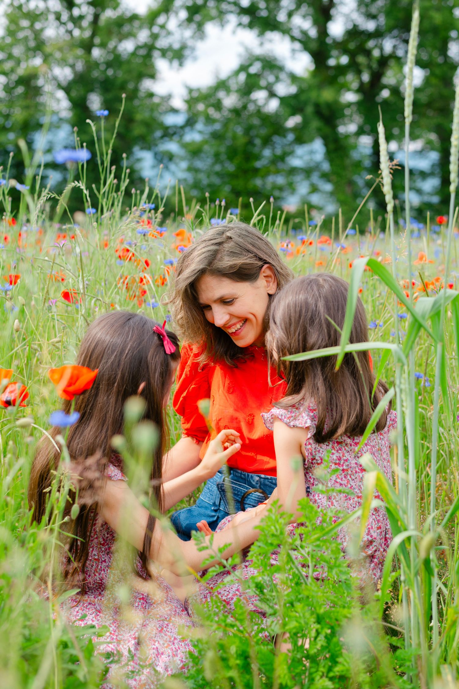 A joyful gathering among vibrant red poppies and tall grasses in a summer meadow on a bright sunny day.