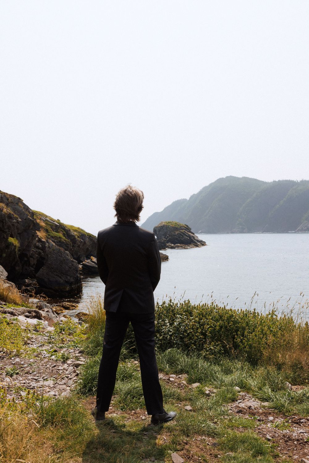 Bride and groom share first look in Dunfield on Bonavista Peninsula by Newfoundland documentary wedding photographer Kaitlyn Yvette