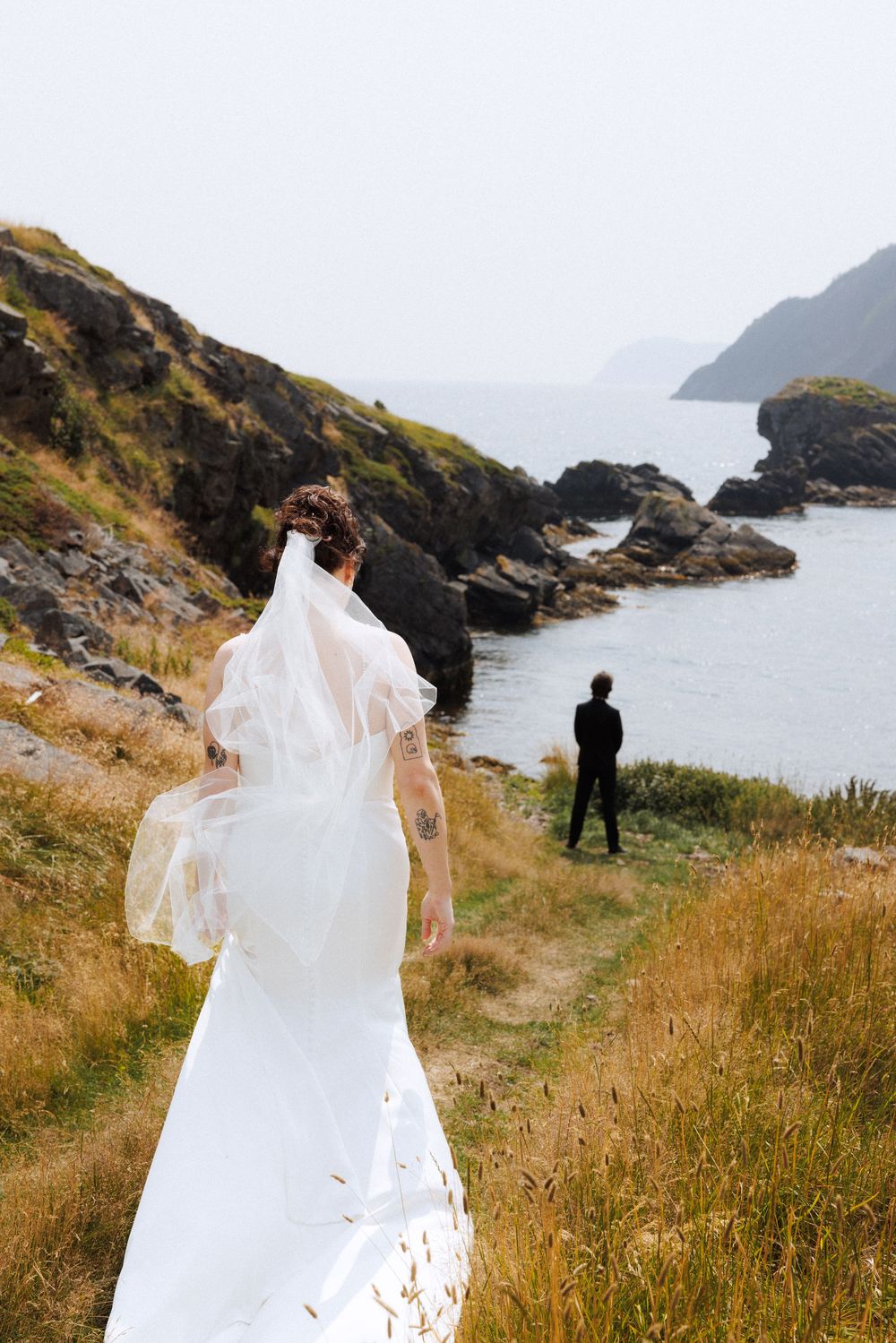 Bride and groom share first look in Dunfield on Bonavista Peninsula by Newfoundland documentary wedding photographer Kaitlyn Yvette