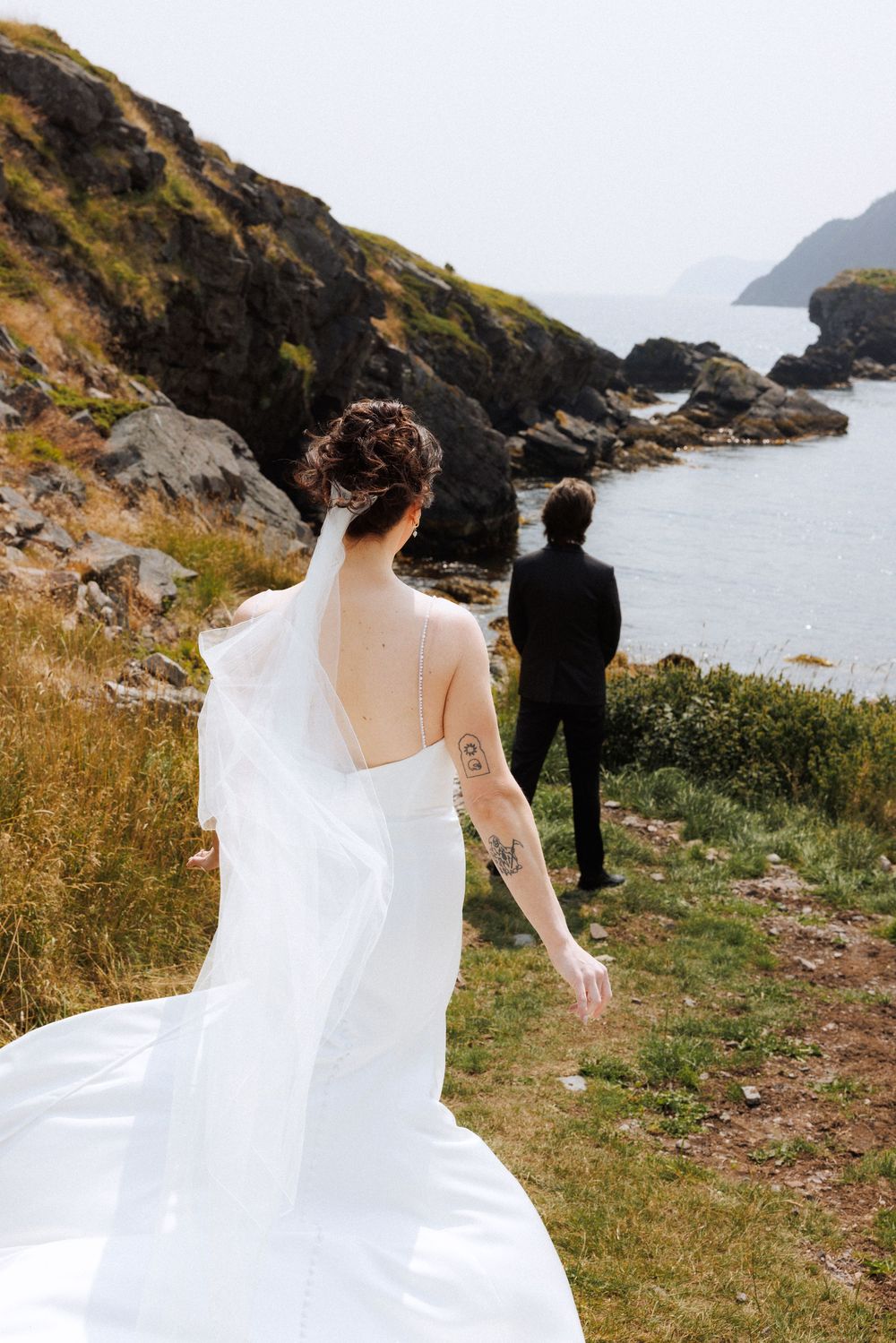 Bride and groom share first look in Dunfield on Bonavista Peninsula by Newfoundland documentary wedding photographer Kaitlyn Yvette