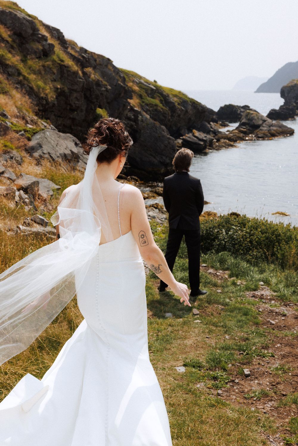 Bride and groom share first look in Dunfield on Bonavista Peninsula by Newfoundland documentary wedding photographer Kaitlyn Yvette