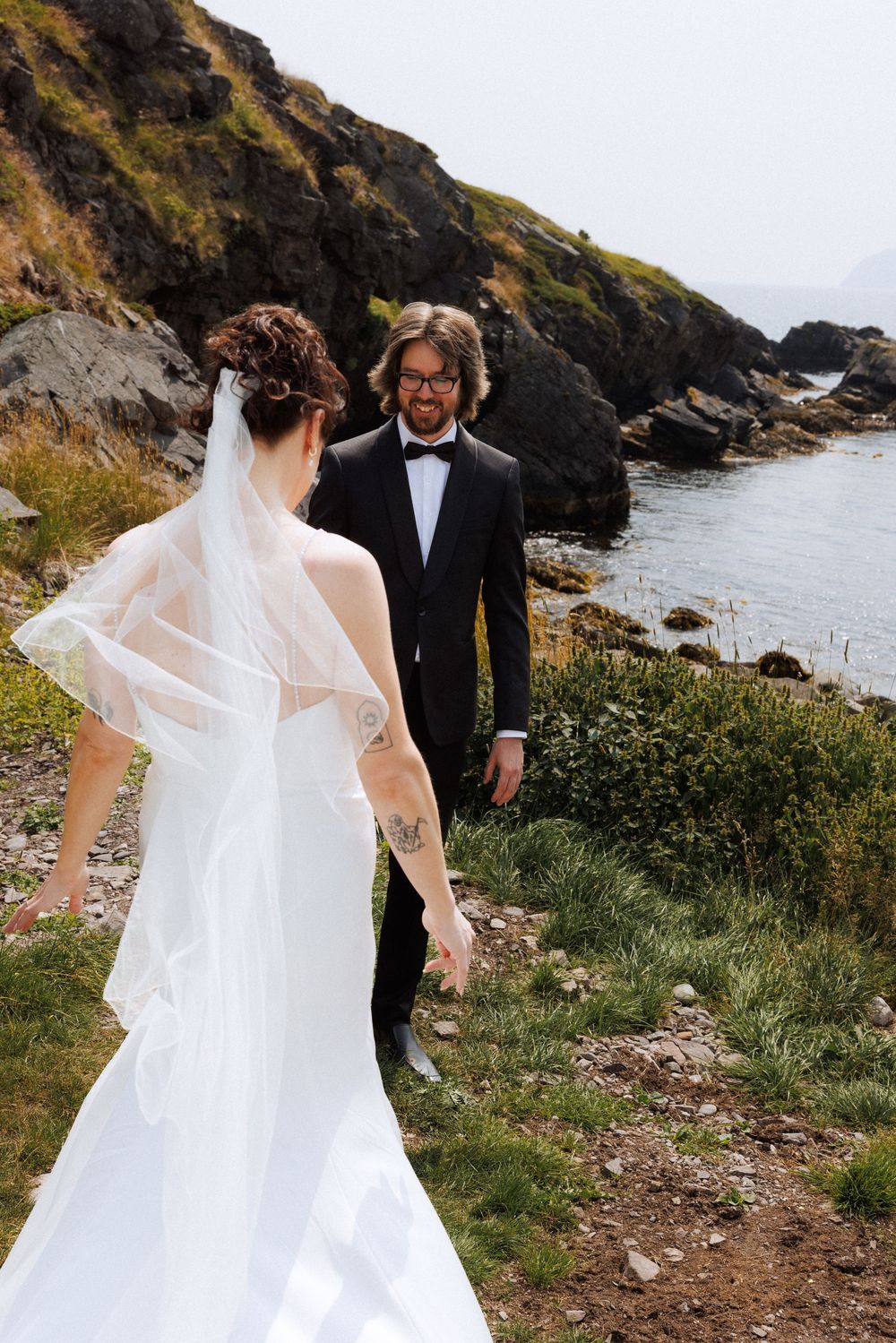 Bride and groom share first look in Dunfield on Bonavista Peninsula by Newfoundland documentary wedding photographer Kaitlyn Yvette
