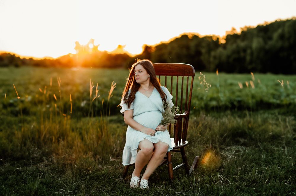 Maternity photoshoot in a rustic outdoor setting during golden hour.