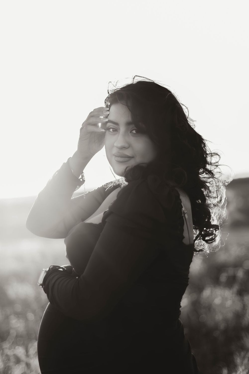 Silhouette portrait against bright sunlight with windswept hair.