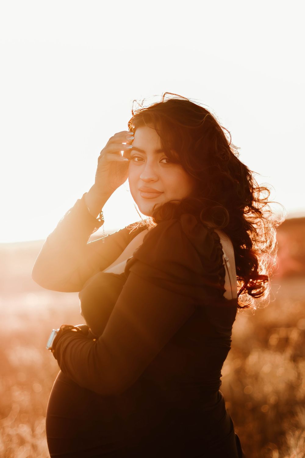 Artistic backlit portrait with sun flare and flowing hair.