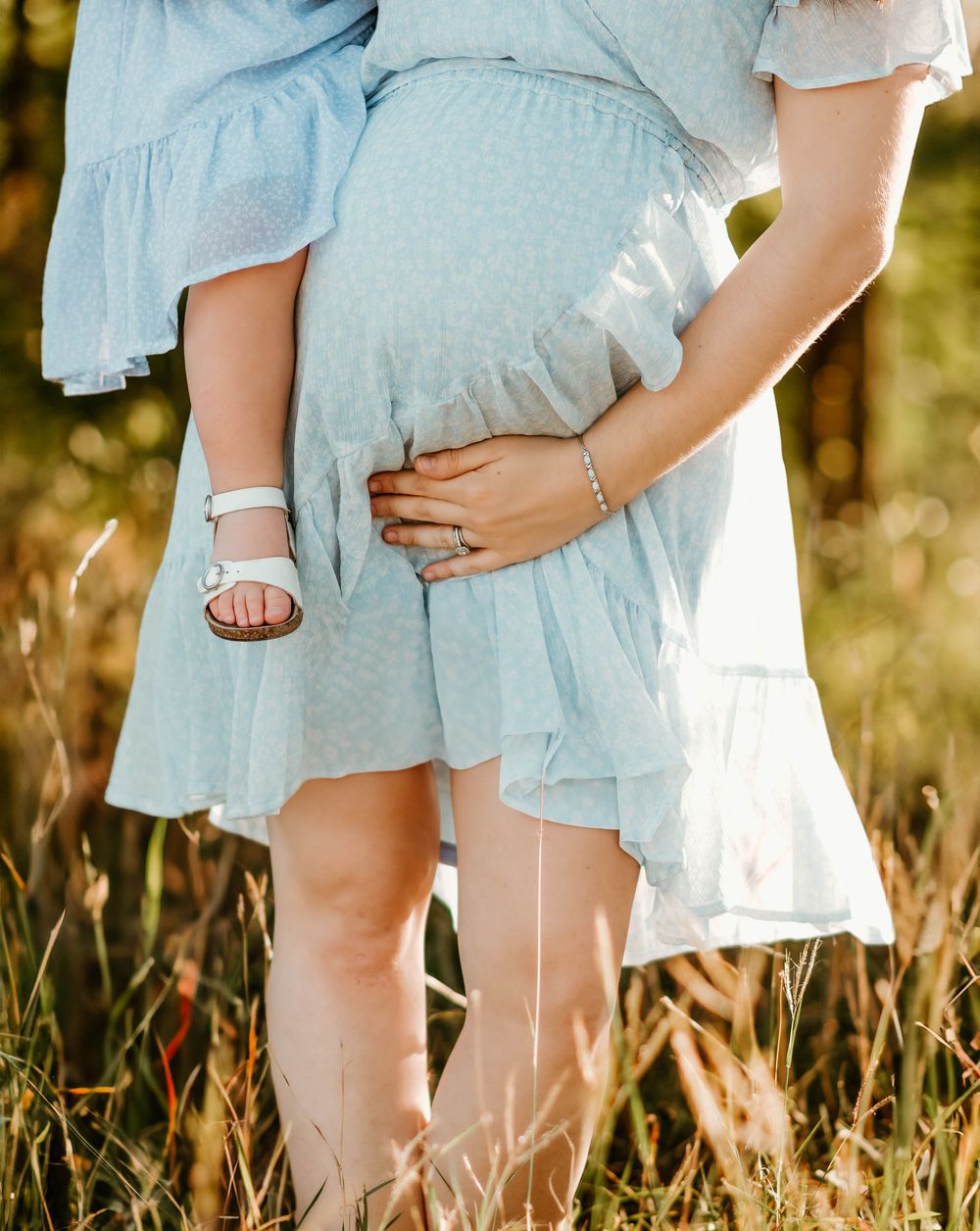 Candid photo of matching blue dresses against tall grass in natural lighting.