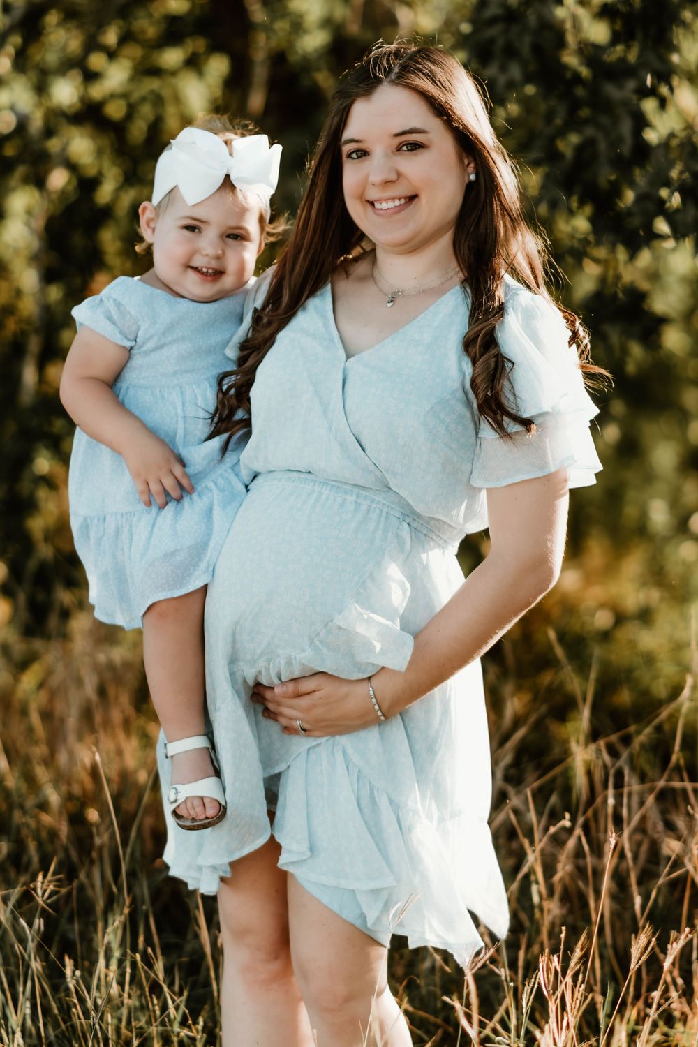 Candid outdoor portrait of family members wearing coordinating blue outfits against natural background.