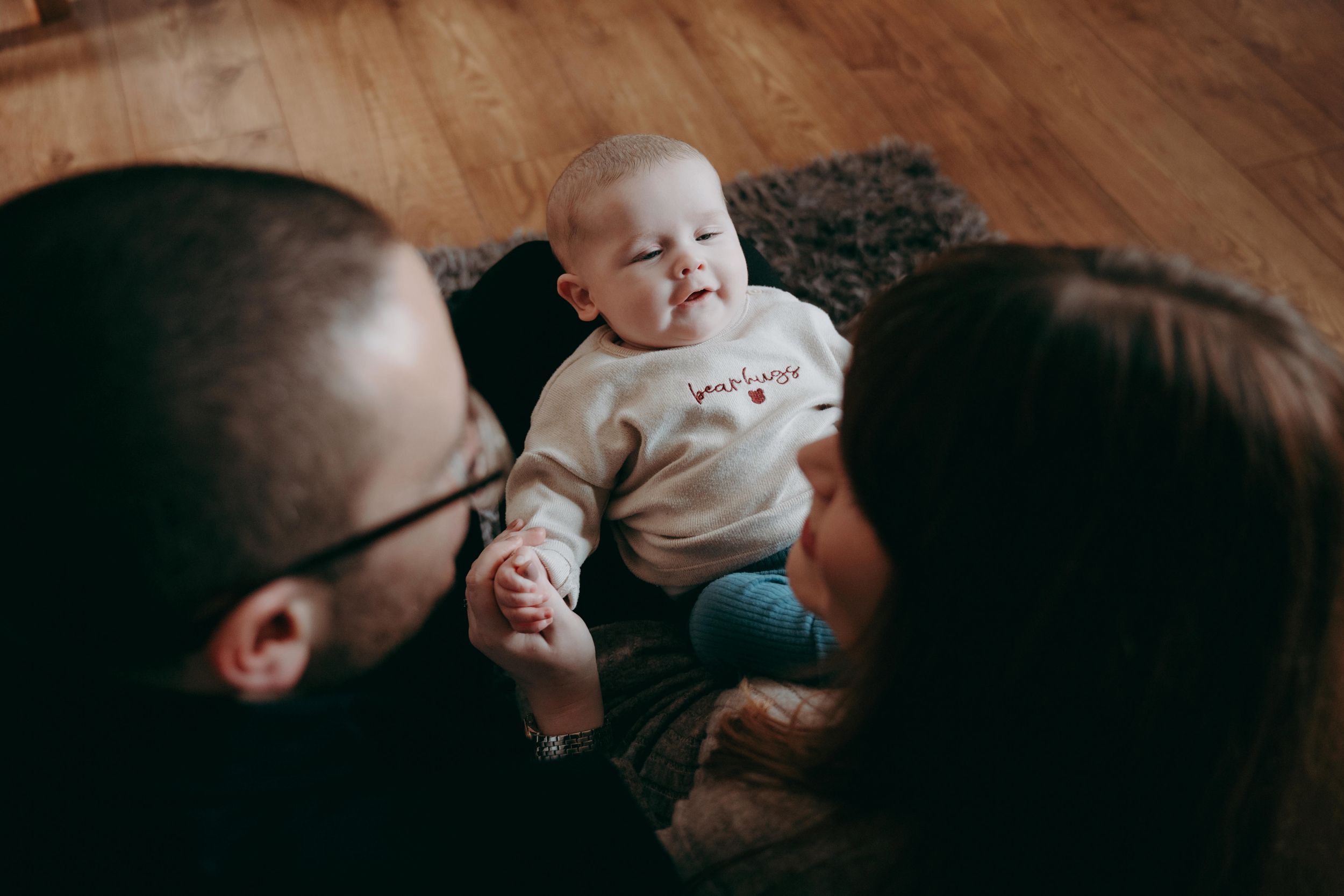 A tender family moment captured in a series of black and white photographs showing parents with their newborn baby.