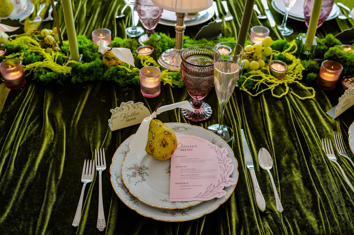 Elegant wedding table setting with pink and white floral centerpieces, crystal glassware, and tropical palm leaves.