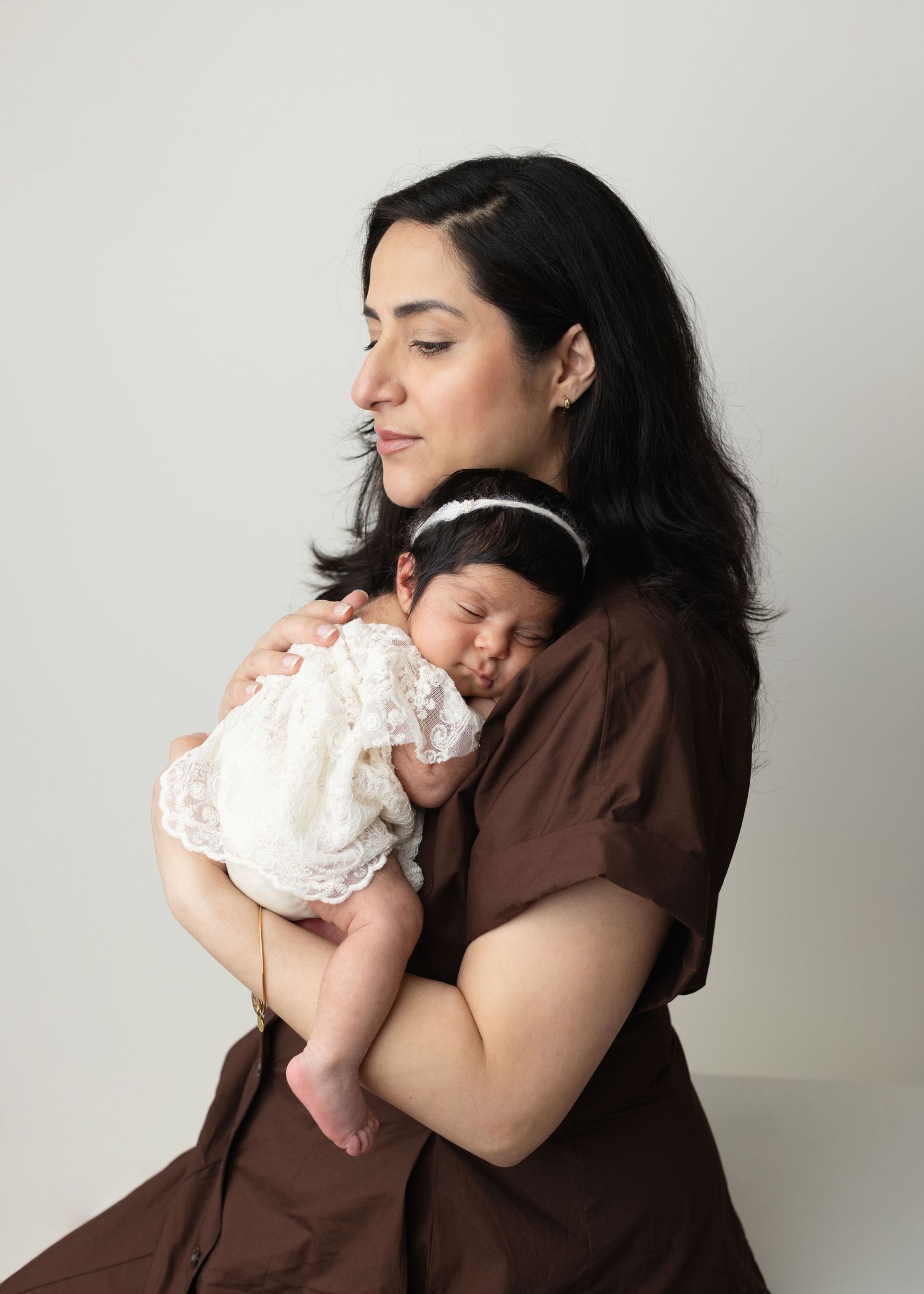 A series of intimate mother and baby portraits showing loving embraces against a white backdrop. Elizabeth Lang Photography Surrey