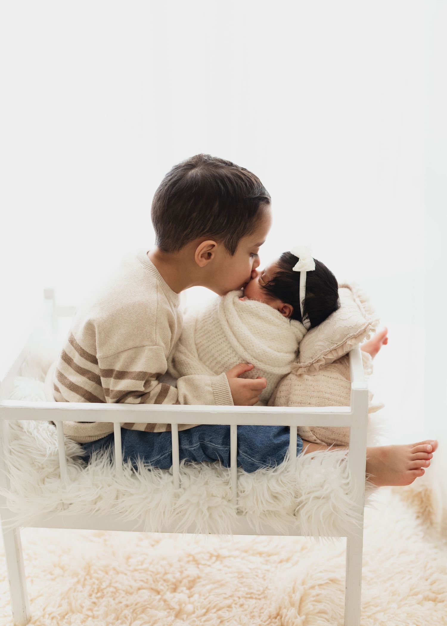 A child lies on a white bench reading a book in a cozy room with soft lighting and neutral decor. Elizabeth Lang Photography Surrey