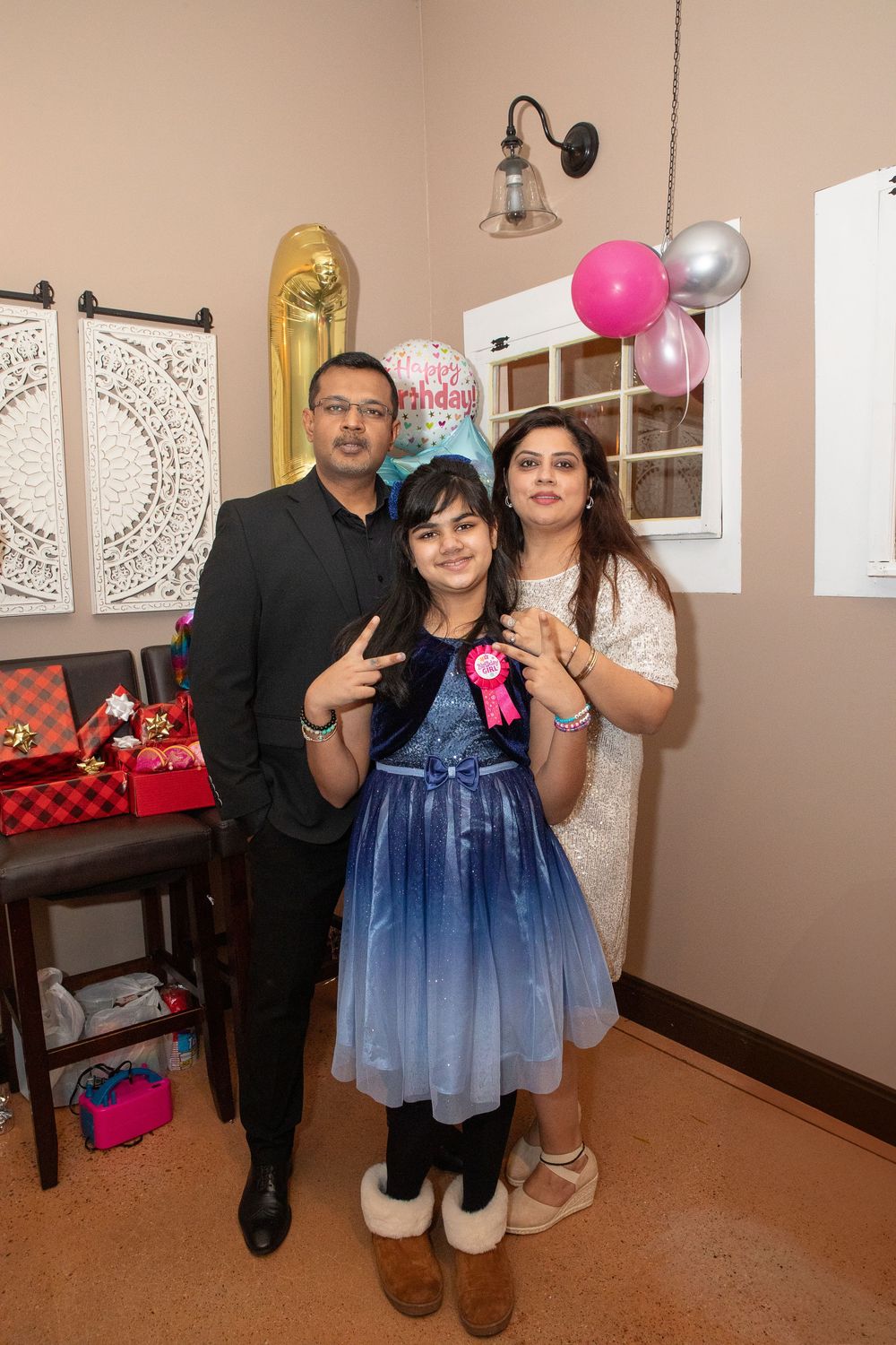 A series of party photos showing people holding balloons in a room decorated with wall art and pink accents.