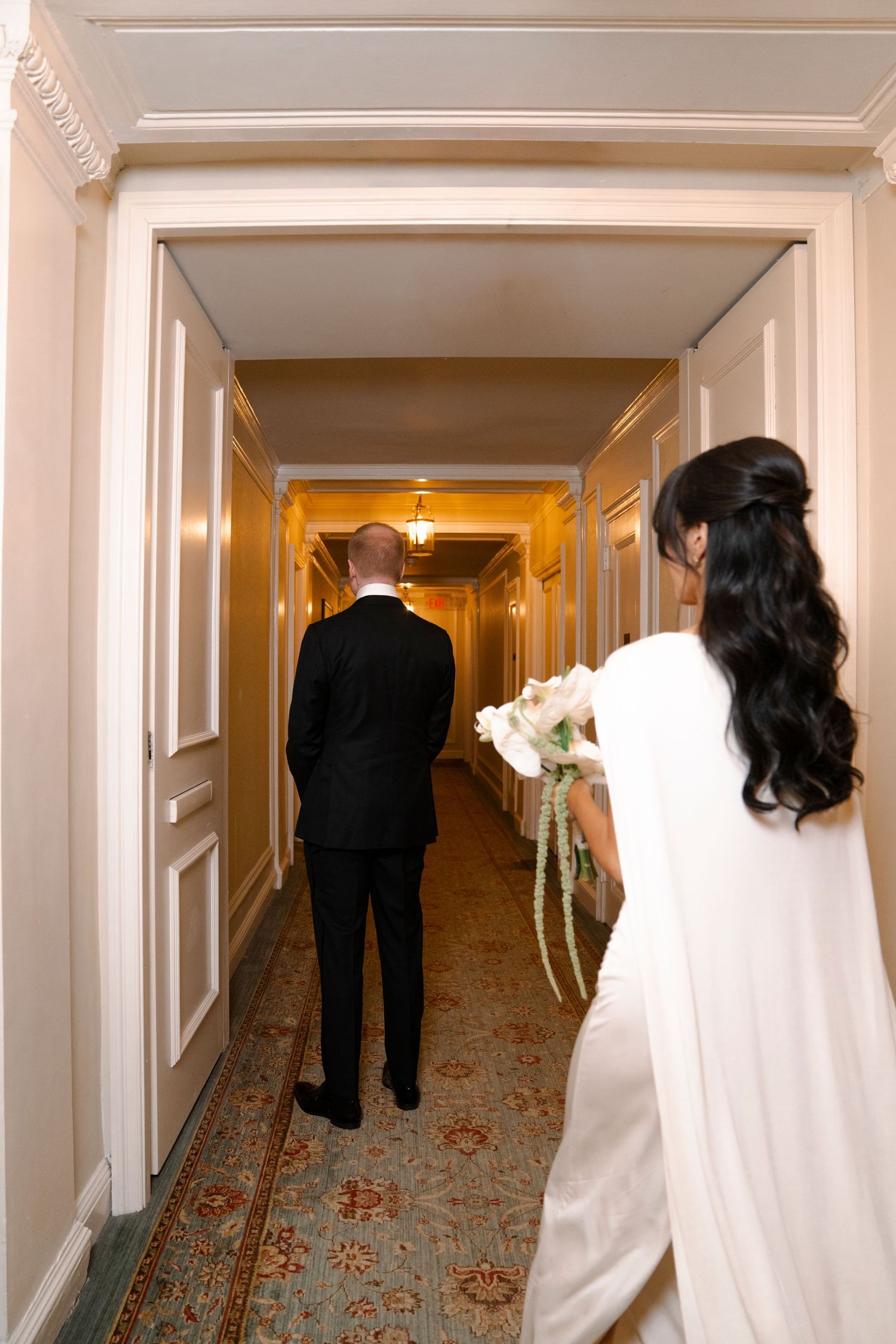A sequence of four photos showing a couple walking down a hotel hallway in wedding attire.