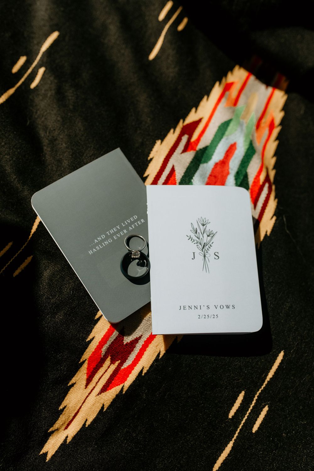 Business cards displayed on dark fabric with minimalist floral designs and branding.