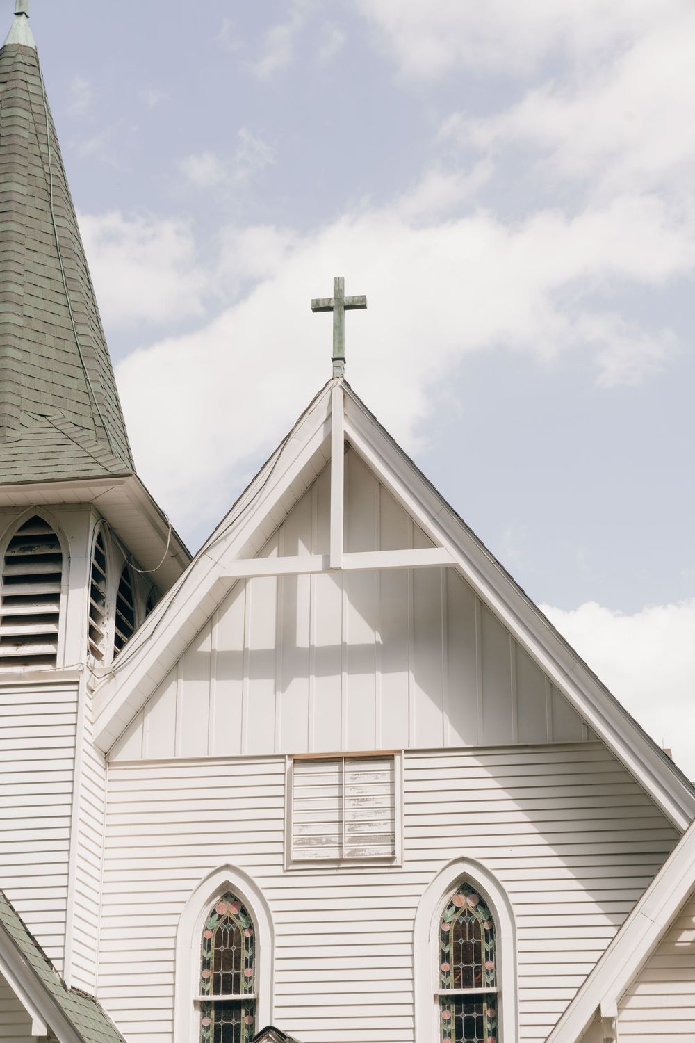 Row of white church steeples with crosses and arched windows against a cloudy sky.