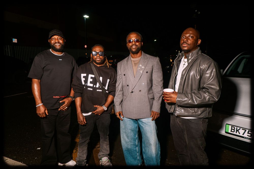 A group of people standing together at a nighttime gathering or social event.