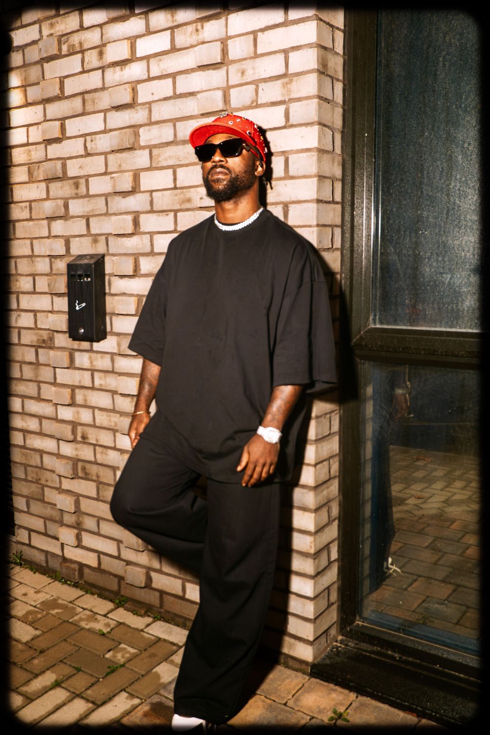Artistic series of photos showing a person in black clothing against a brick wall with dramatic lighting and shadows.