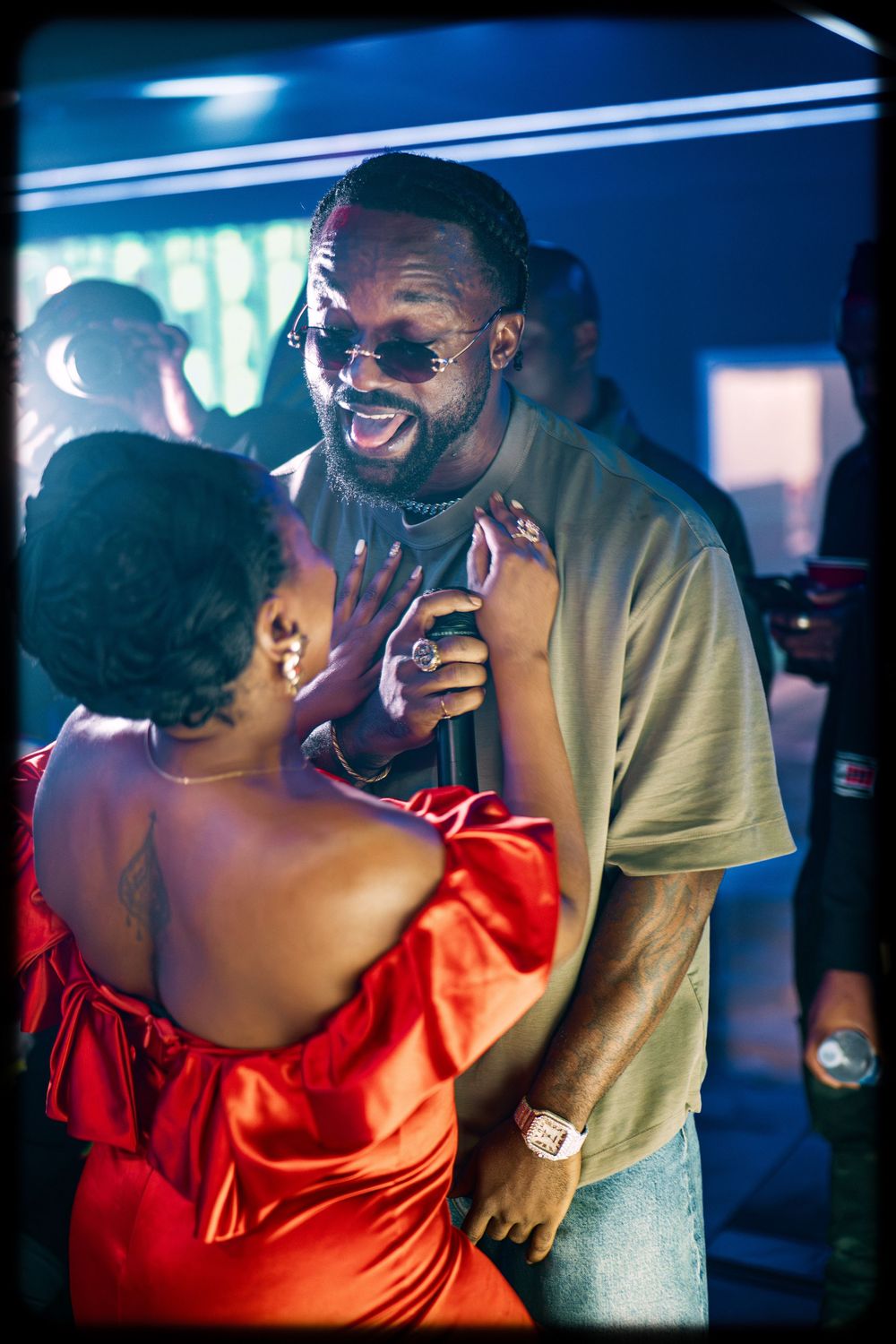 A couple shares an intimate dance moment in a dimly lit nightclub with blue lighting and romantic atmosphere.