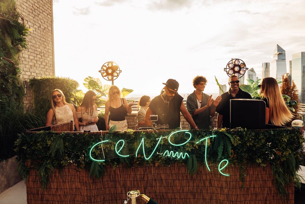 A crowd of people gathered outdoors at sunset with warm lighting and a festive atmosphere.
