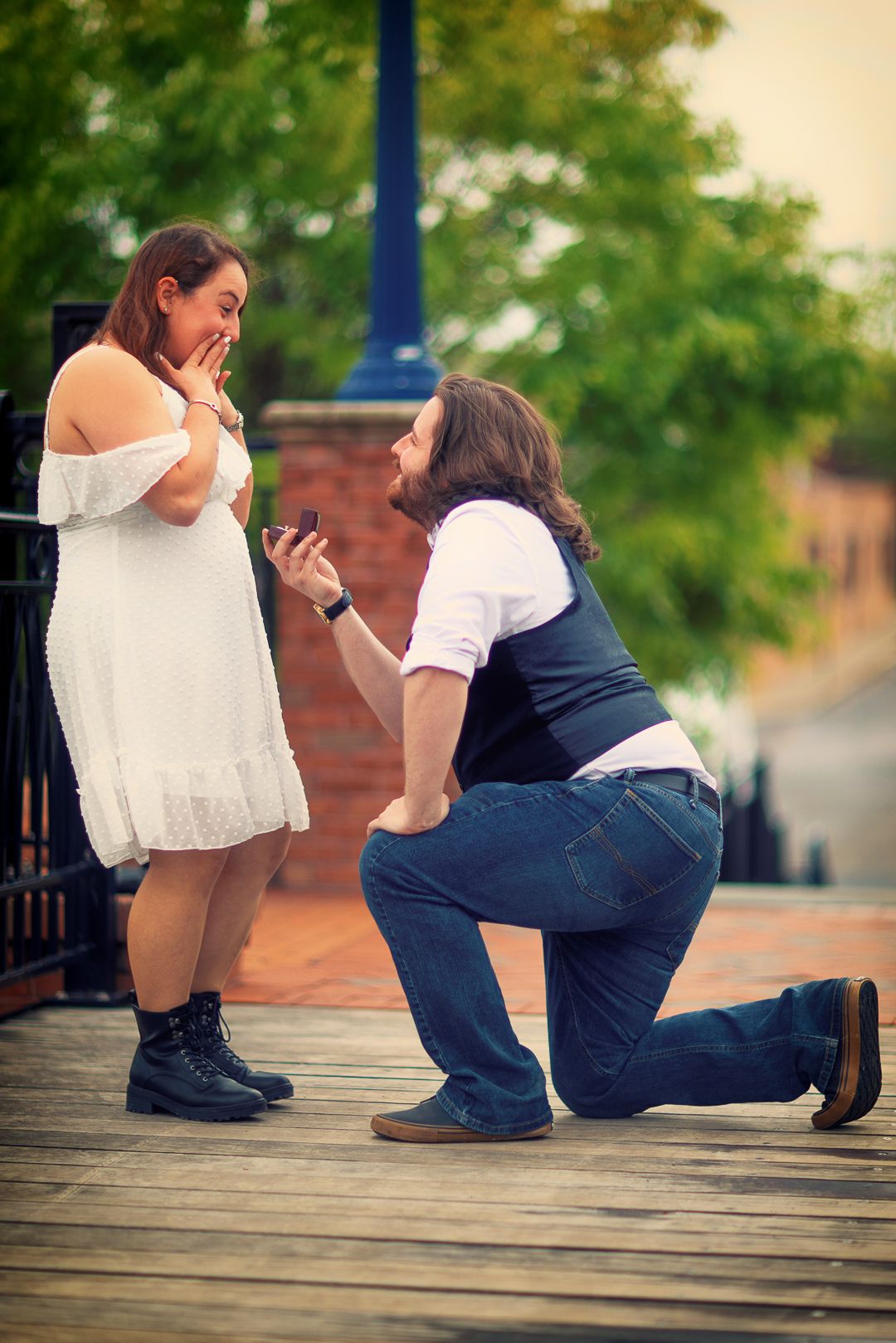 A romantic proposal sequence showing a couple on a wooden deck during sunset.