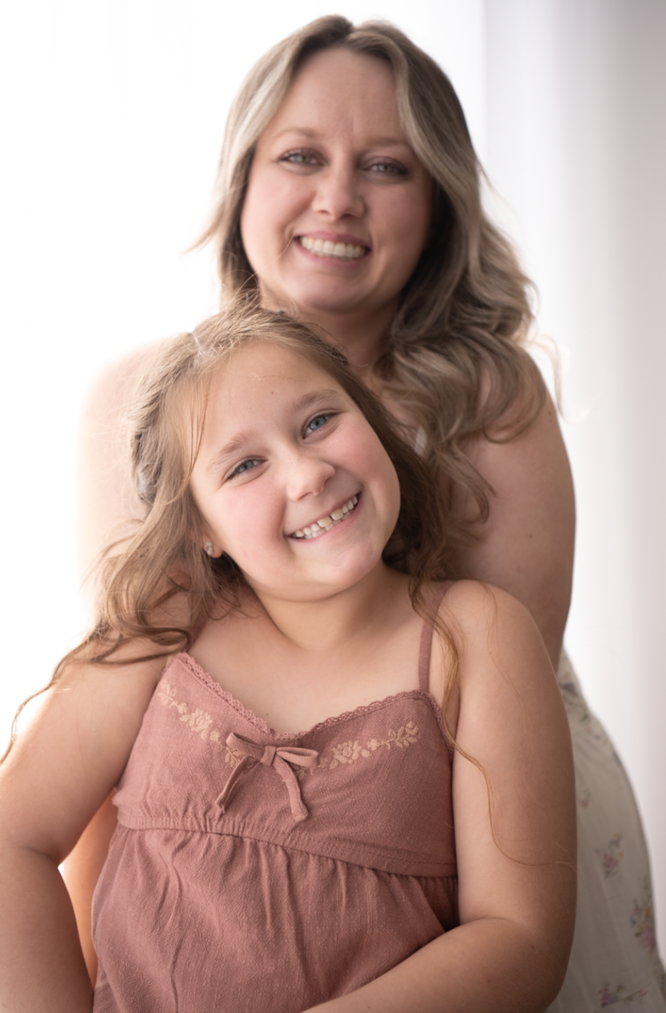 A heartwarming series of portrait photos showing tender moments between parent and child in soft pink tones.