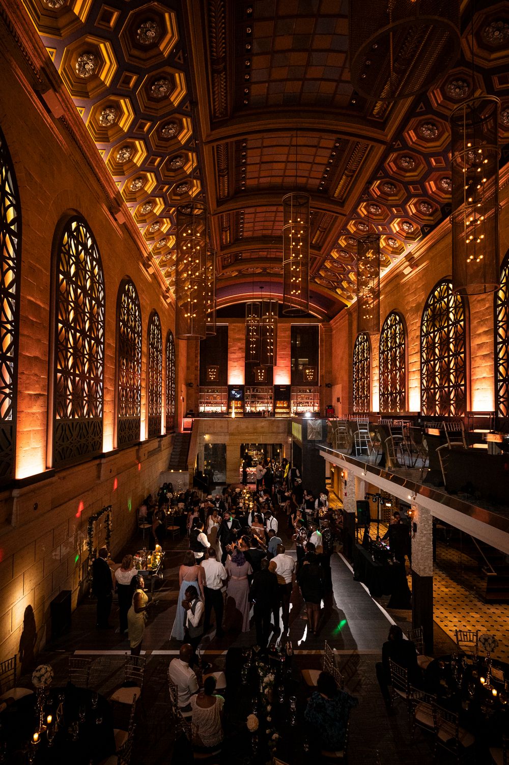 Elegant ballroom reception venue and ornate architectural details filled with wedding guests.