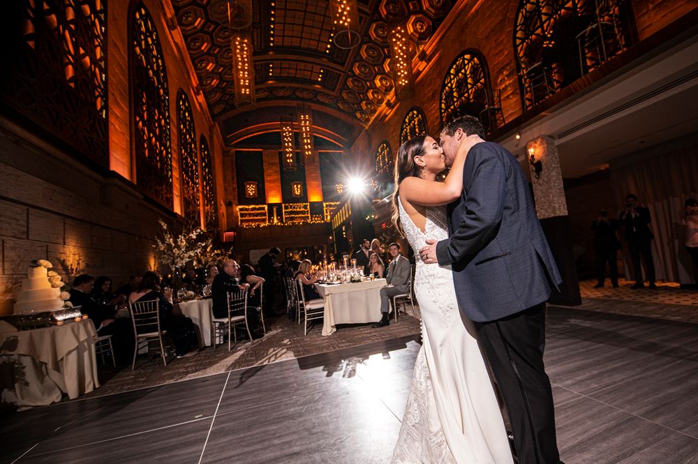 Couple dancing in an elegant indoor venue with warm lighting and dramatic architecture at a Union Trust wedding
