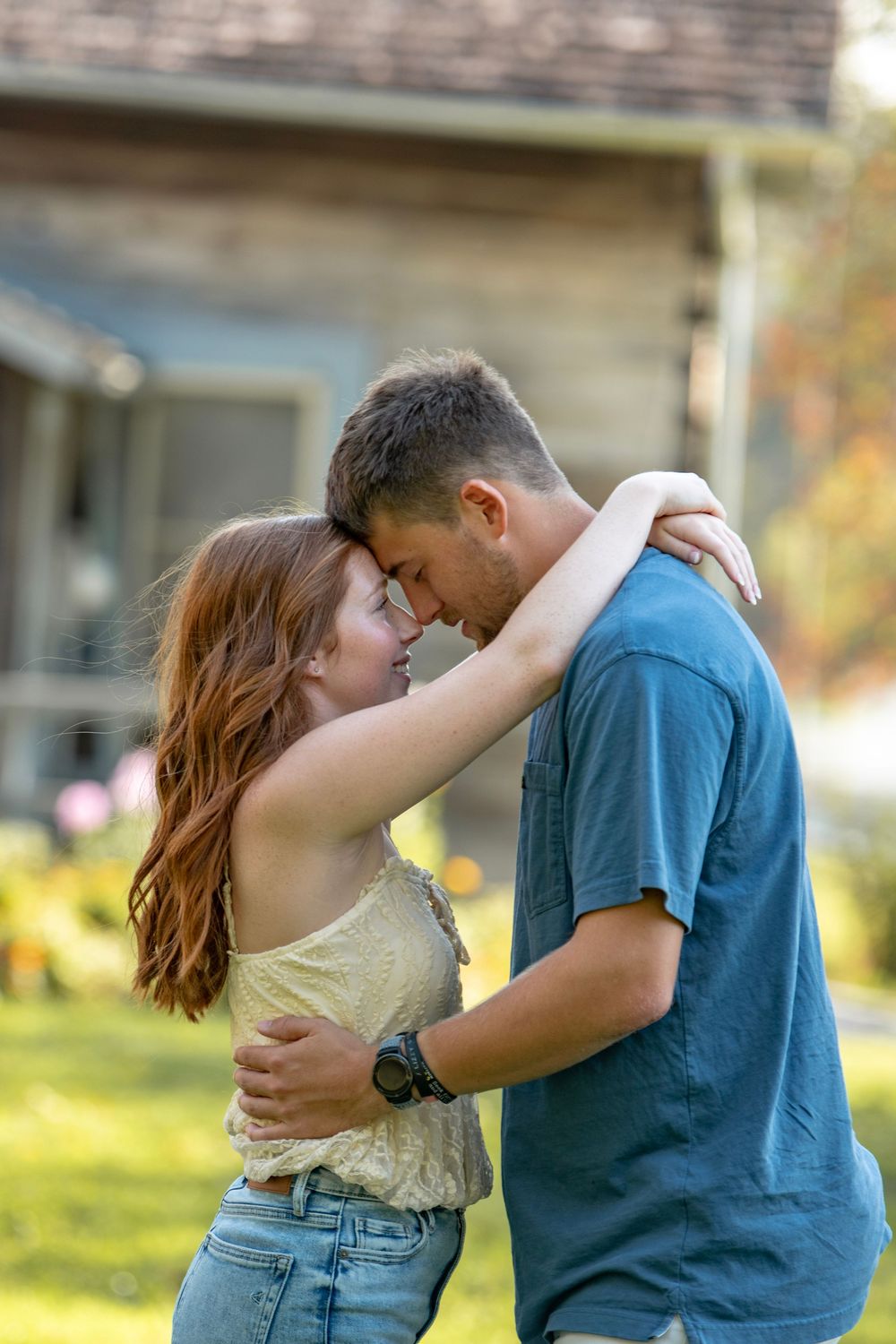 A couple shares intimate moments in a garden setting during golden hour.