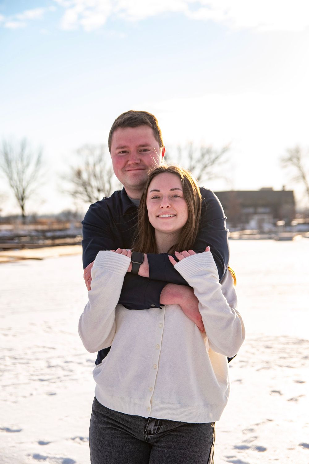 Playful winter portrait session in snow with white sweaters and casual style.