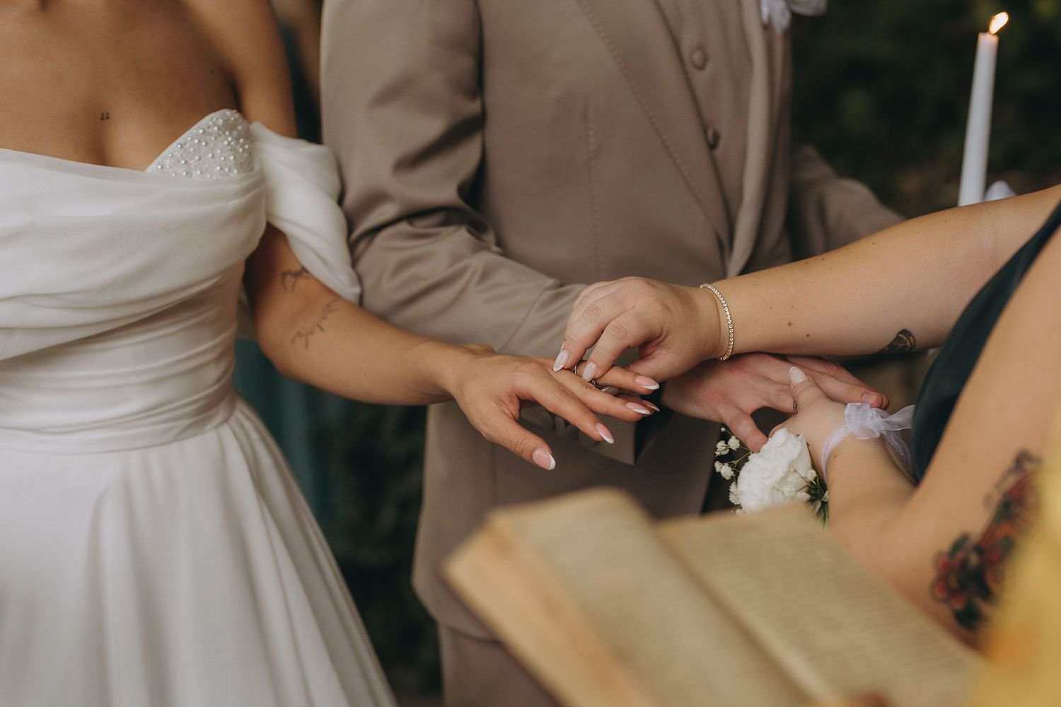 Bride and groom exchanging rings during wedding ceremony, close-up of hands with ring placement.