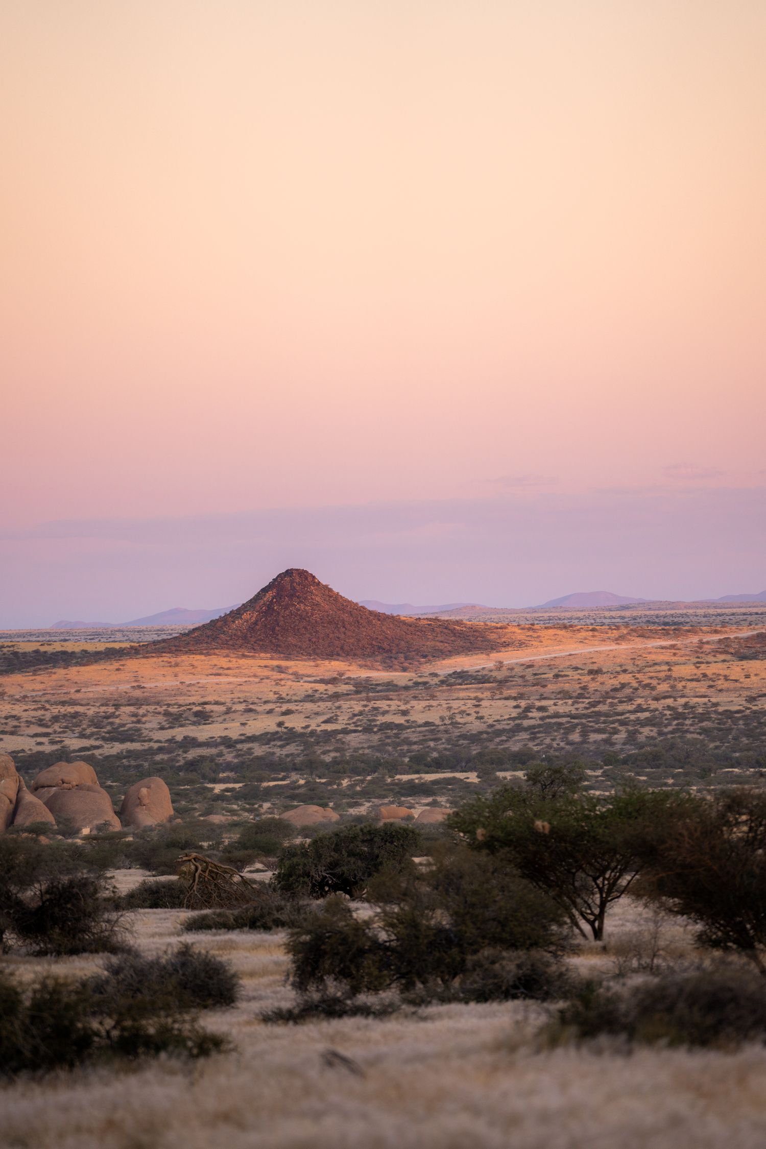coucher de soleil sur la plaine de namibie à spitkoppe avec une formation volcanique