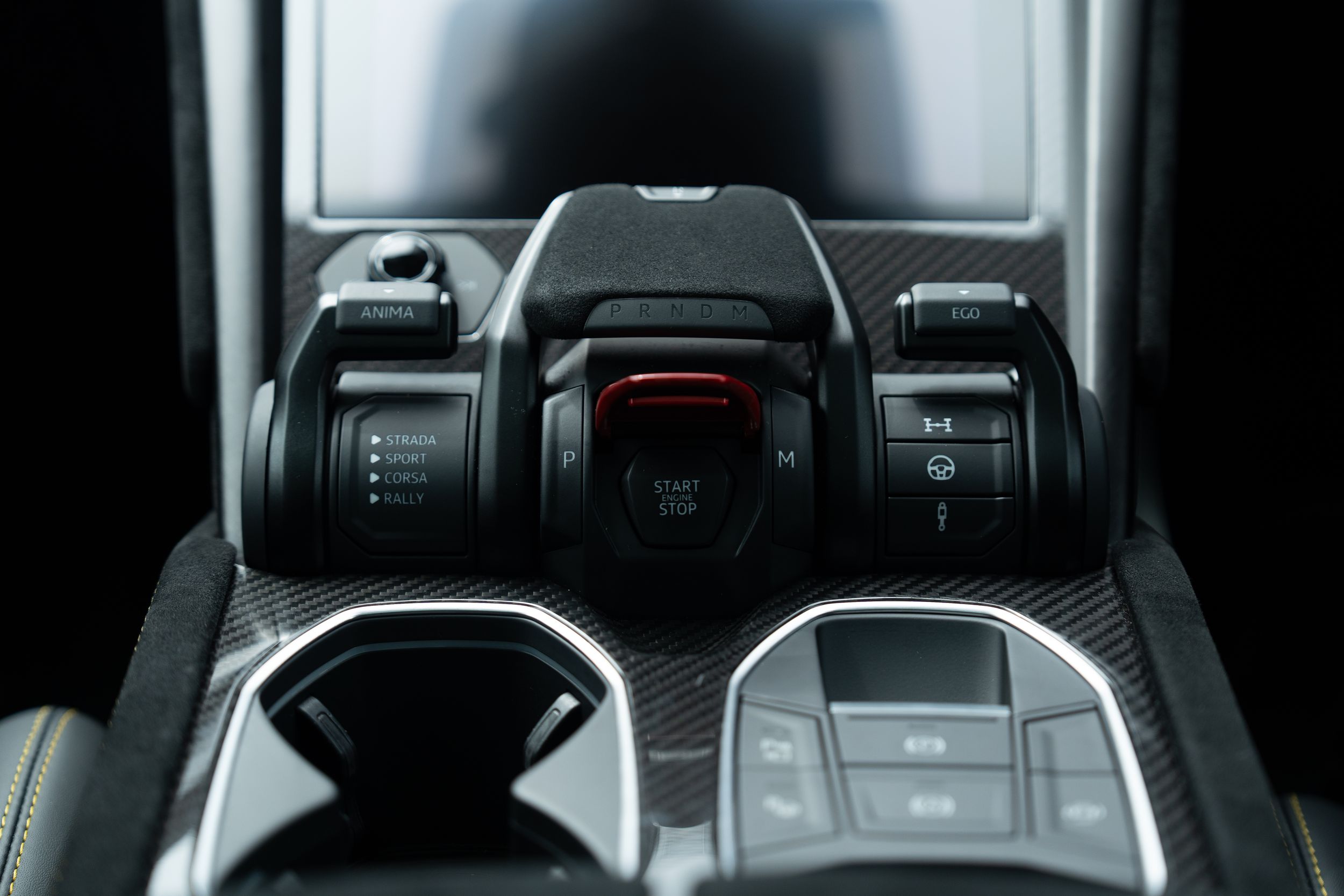 Lamborghini Urus center console controls featuring drive mode selectors and carbon fiber trim details.
