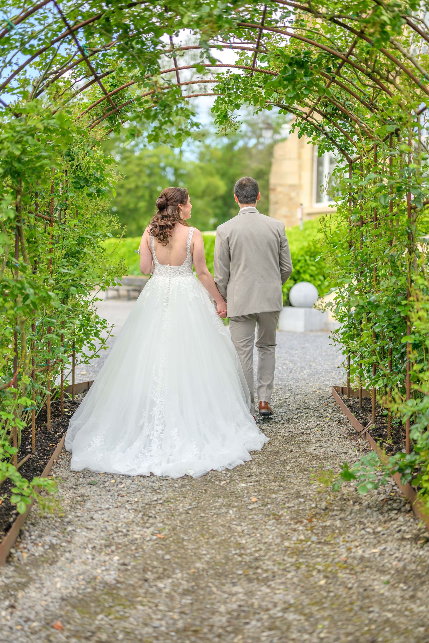 A romantic wedding couple poses in a series of elegant shots under stone archways at a historic European castle.